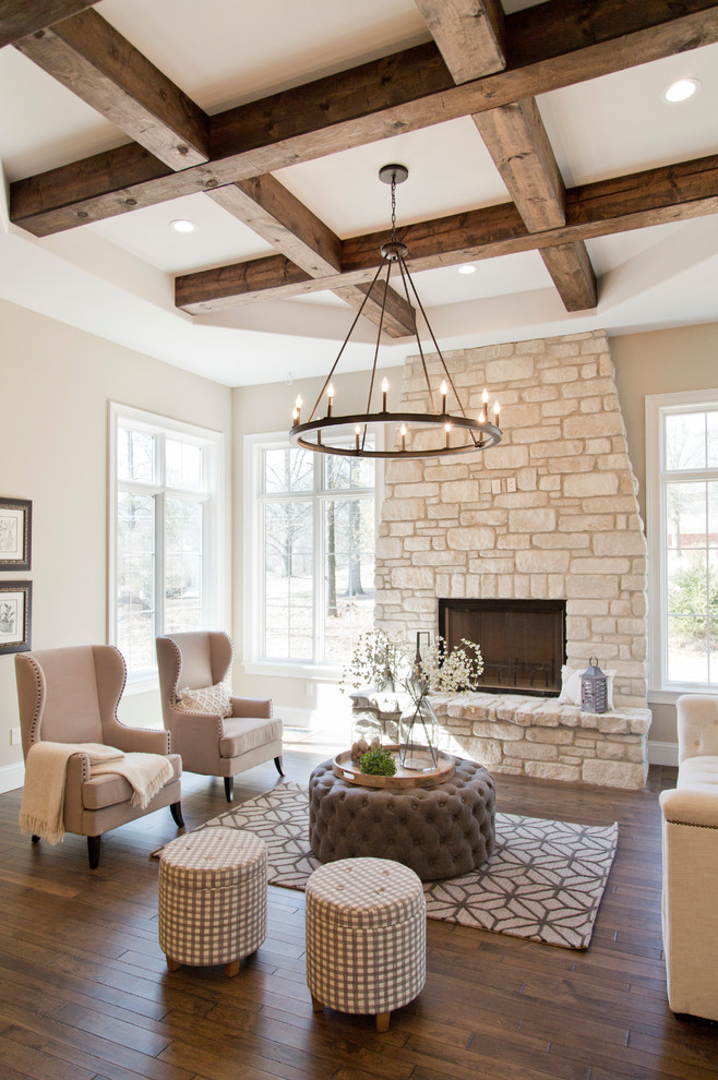 Medium sized farmhouse open plan games room in St Louis with beige walls, a standard fireplace, a stone fireplace surround, no tv, brown floors and dark hardwood flooring.