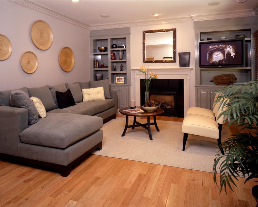 На фото: изолированная гостиная комната среднего размера в классическом стиле с фиолетовыми стенами, паркетным полом среднего тона, стандартным камином, фасадом камина из дерева, телевизором на стене и коричневым полом