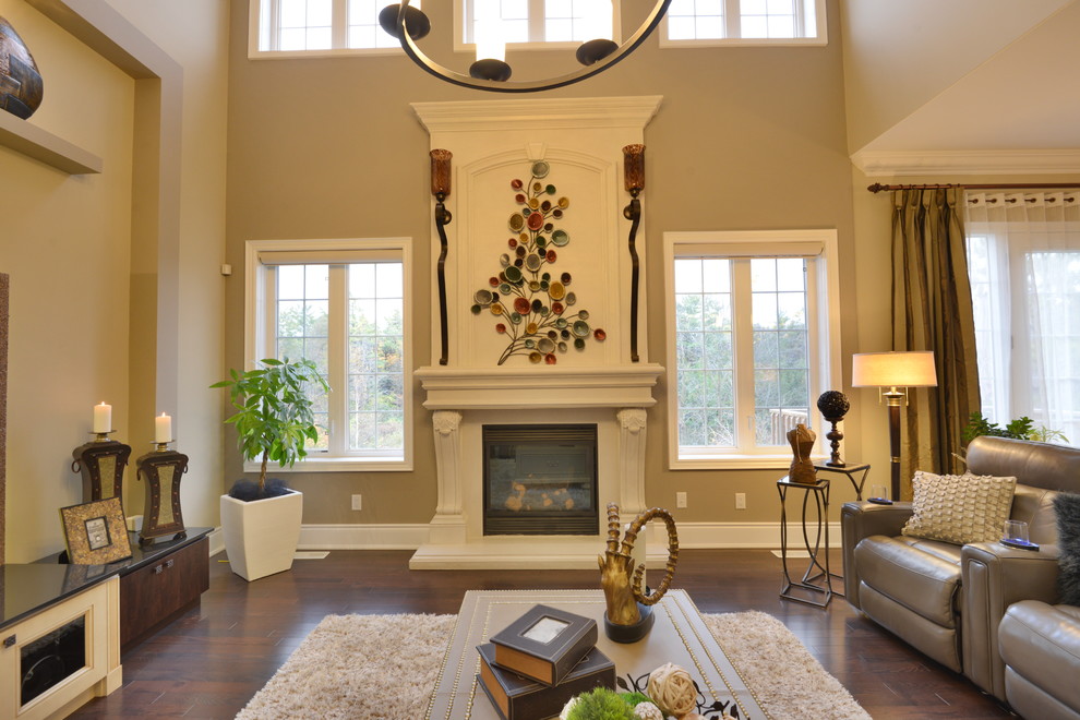 Mid-sized transitional open concept dark wood floor and beige floor family room photo in Toronto with beige walls, a standard fireplace, a wood fireplace surround and a wall-mounted tv