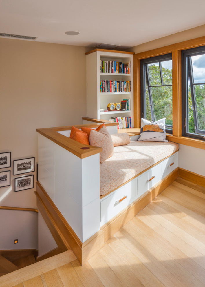 Foto di un soggiorno stile marino con libreria, pareti beige, parquet chiaro e pavimento beige