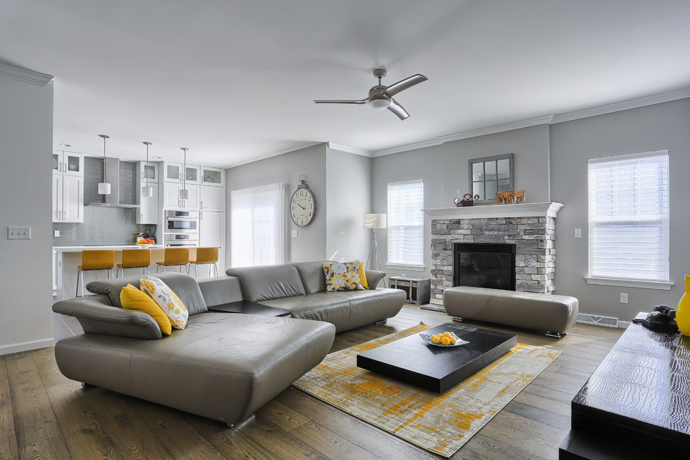 Foto di un soggiorno minimalista di medie dimensioni e aperto con pareti grigie, pavimento in legno massello medio e cornice del camino in pietra