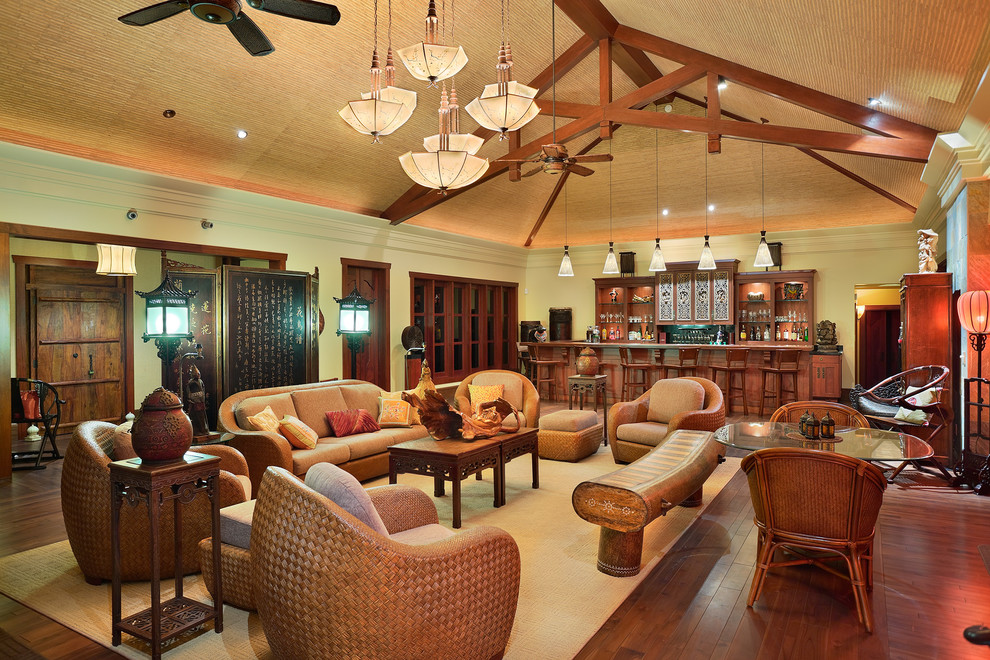 Diseño de salón con barra de bar abierto asiático grande sin chimenea y televisor con paredes verdes y suelo de madera en tonos medios