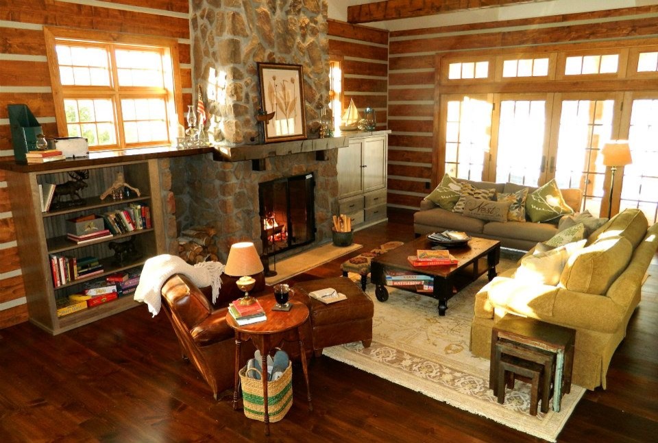 Example of a large mountain style loft-style dark wood floor family room design in Minneapolis with a standard fireplace, a stone fireplace and a media wall