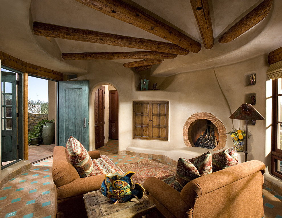 Aménagement d'une salle de séjour sud-ouest américain fermée avec un mur beige, tomettes au sol, une cheminée standard, un manteau de cheminée en brique et un sol multicolore.