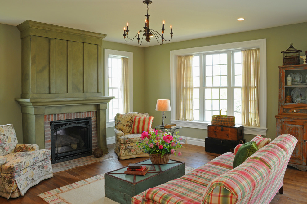 Cette image montre une salle de séjour rustique de taille moyenne et ouverte avec un mur vert, un sol en bois brun, une cheminée standard et un manteau de cheminée en bois.