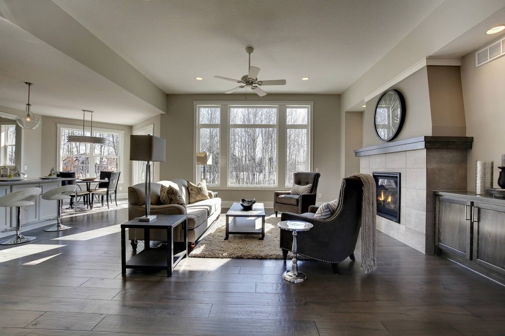 Inspiration for a medium sized classic open plan games room in Minneapolis with grey walls, dark hardwood flooring, no tv, a standard fireplace, a tiled fireplace surround and feature lighting.