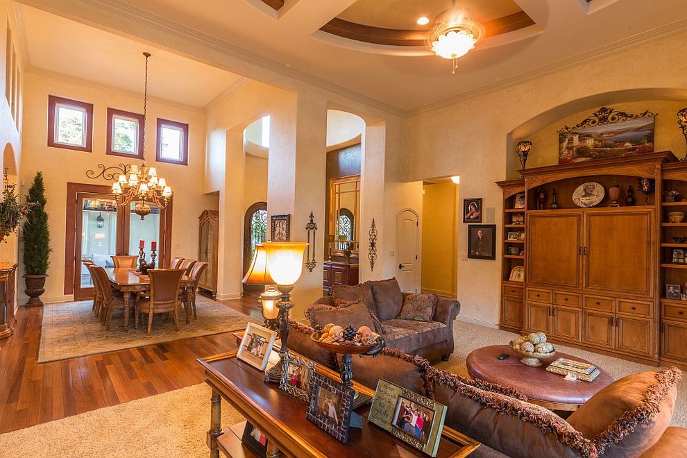 Example of a large tuscan open concept carpeted family room design in Other with a media wall