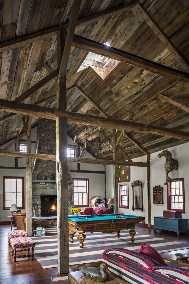 Geräumiger Landhaus Hobbyraum mit weißer Wandfarbe, dunklem Holzboden, Kamin und Kaminumrandung aus Stein in New York