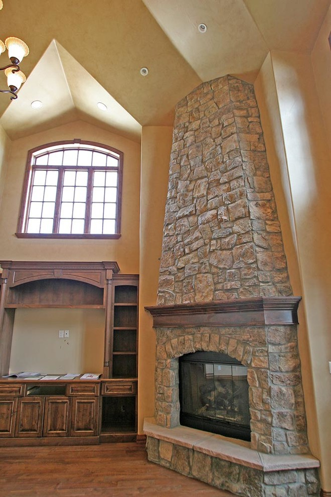Foto de sala de estar tradicional con todas las chimeneas y marco de chimenea de piedra
