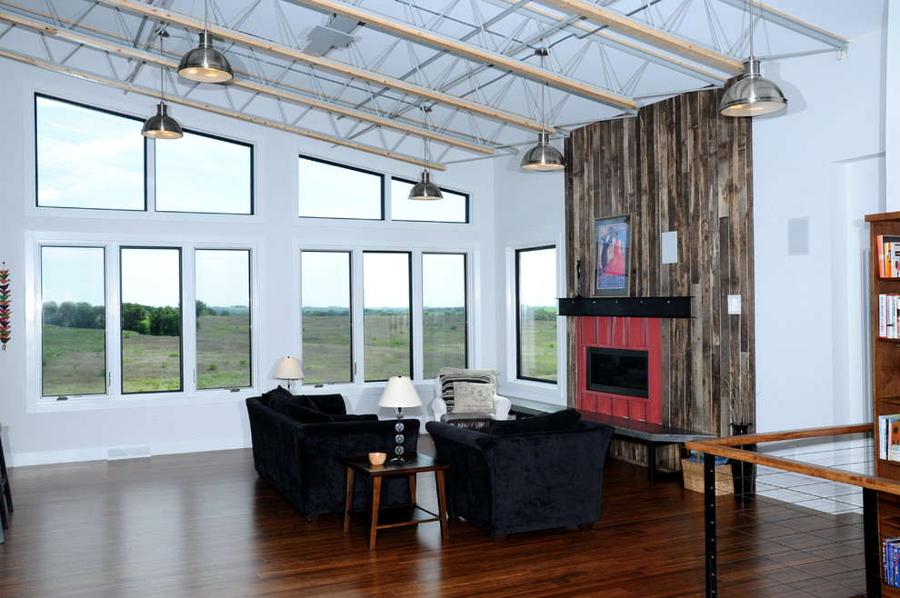 Medium sized industrial open plan games room in Other with white walls, medium hardwood flooring, a standard fireplace and a metal fireplace surround.