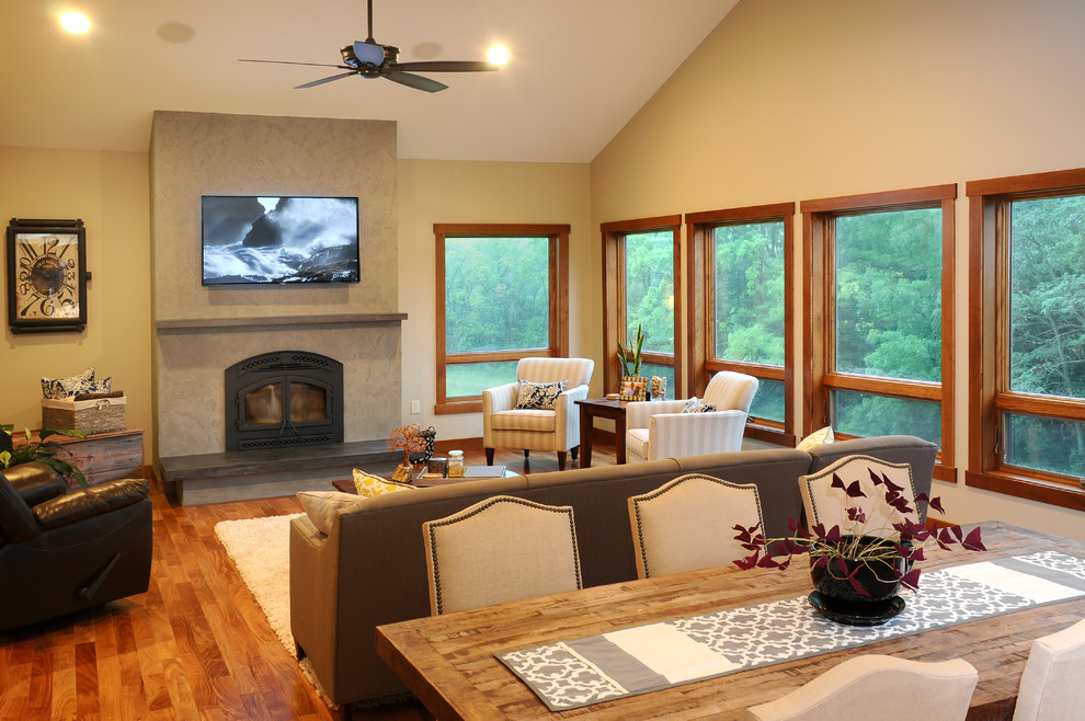 Cette photo montre une petite salle de séjour ouverte avec un mur beige, un sol en bois brun, une cheminée standard, un manteau de cheminée en plâtre et un téléviseur fixé au mur.