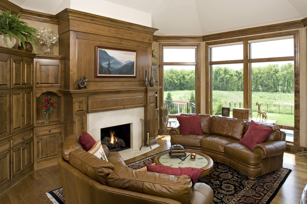 Aménagement d'une salle de séjour classique avec un mur beige, un sol en bois brun, une cheminée standard et un manteau de cheminée en pierre.