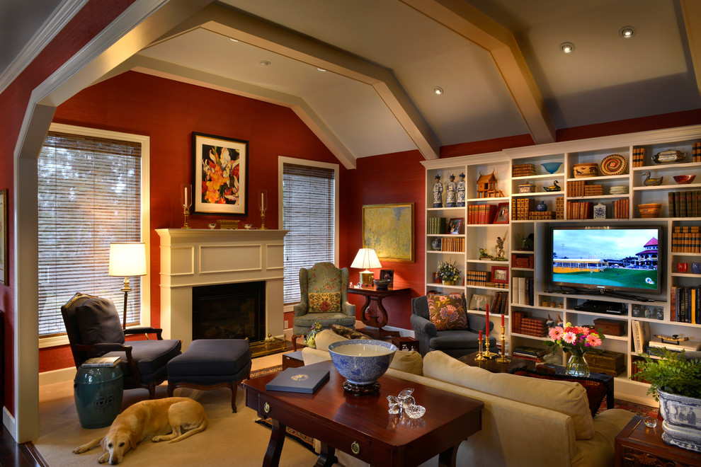 Immagine di un soggiorno american style aperto con libreria, pareti rosse, moquette, camino classico, cornice del camino in legno e parete attrezzata