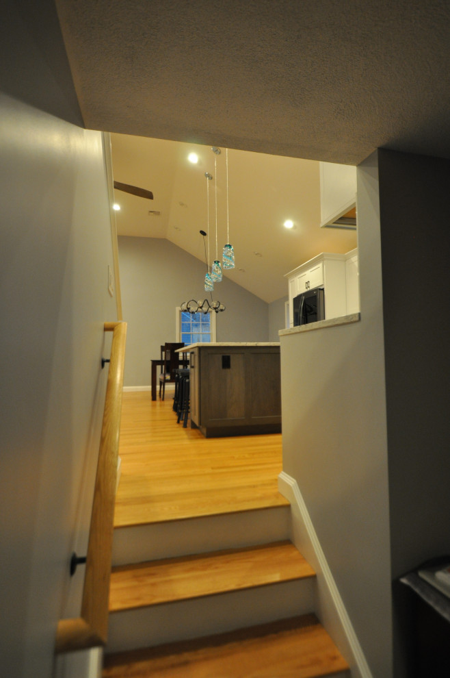 На фото: открытая гостиная комната среднего размера в стиле фьюжн с серыми стенами, светлым паркетным полом, коричневым полом и сводчатым потолком с