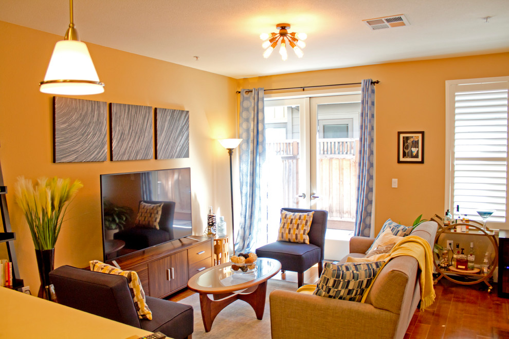Mittelgroßes, Offenes Klassisches Wohnzimmer ohne Kamin mit freistehendem TV, gelber Wandfarbe, braunem Holzboden und braunem Boden in San Francisco
