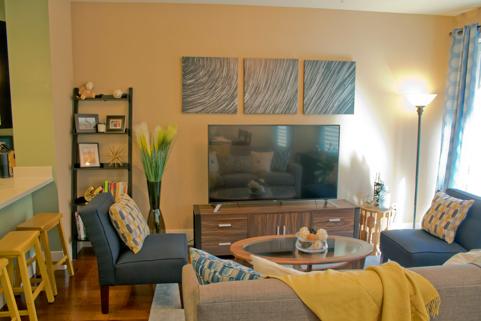 Exemple d'une salle de séjour chic de taille moyenne et ouverte avec aucune cheminée, un téléviseur indépendant, un mur jaune, un sol en bois brun et un sol marron.