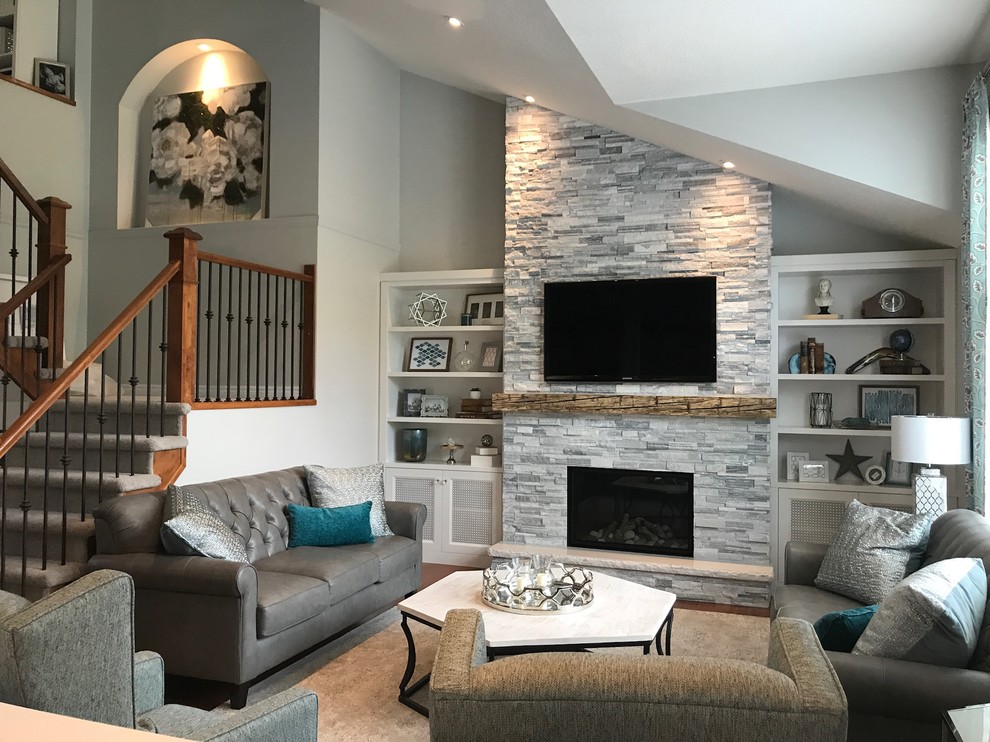 Großes, Offenes Modernes Wohnzimmer mit grauer Wandfarbe, braunem Holzboden, Kamin, Kaminumrandung aus Stein, TV-Wand und orangem Boden in Toronto