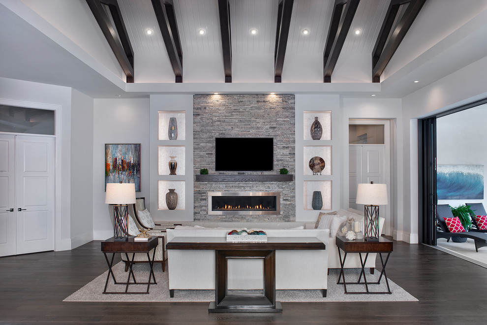 Large transitional open concept dark wood floor and brown floor family room photo in Miami with gray walls, a ribbon fireplace, a metal fireplace and a wall-mounted tv