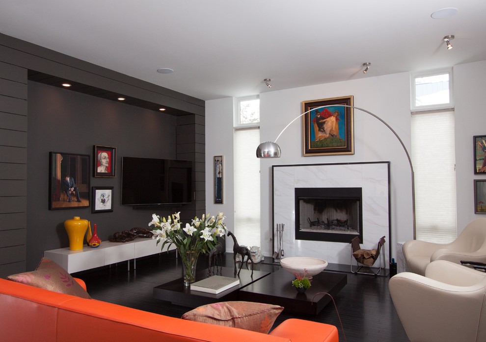 Стильный дизайн: изолированная гостиная комната среднего размера в современном стиле с темным паркетным полом, стандартным камином, телевизором на стене, белыми стенами и фасадом камина из камня - последний тренд