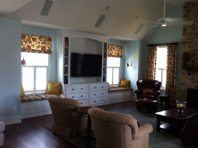 Cette photo montre une grande salle de séjour chic ouverte avec un mur bleu, parquet foncé, une cheminée standard, un manteau de cheminée en pierre et un téléviseur encastré.