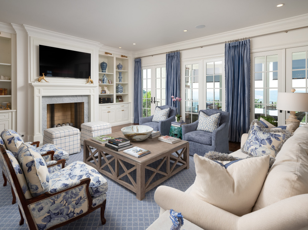 На фото: гостиная комната в морском стиле с белыми стенами, стандартным камином, фасадом камина из камня и телевизором на стене