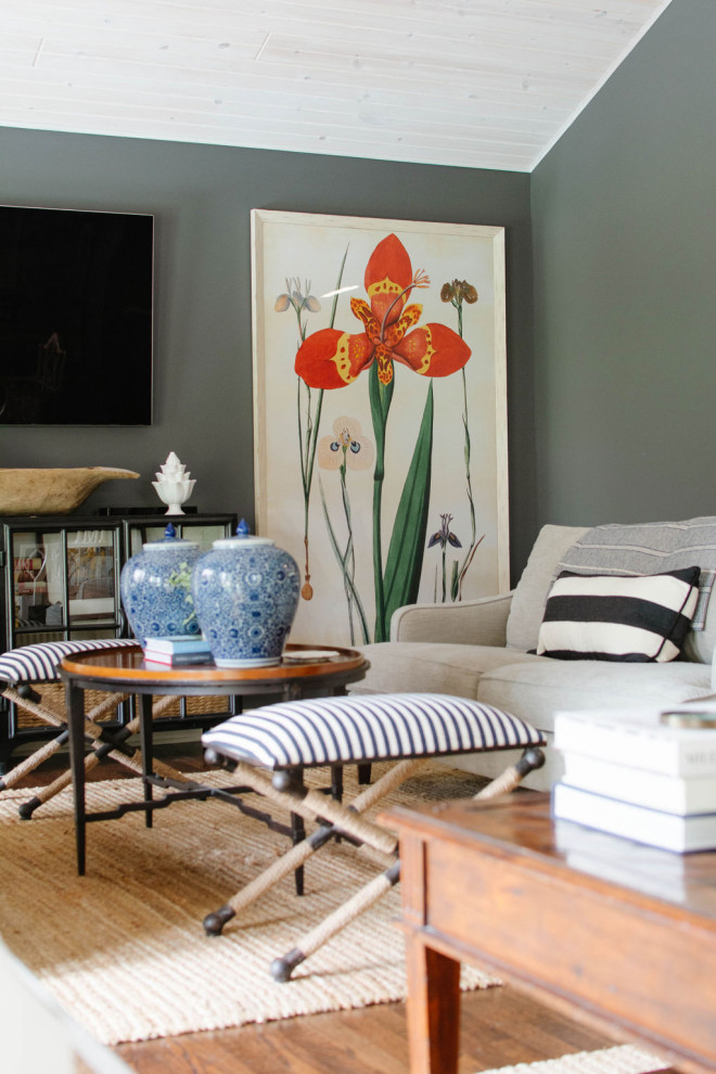 Modelo de sala de estar cerrada tradicional renovada de tamaño medio con paredes verdes, suelo de madera en tonos medios, televisor colgado en la pared y suelo marrón