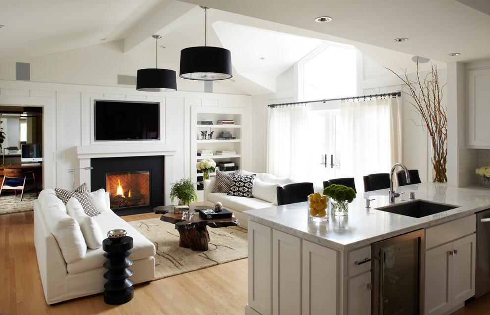 Transitional open concept light wood floor living room photo in San Francisco with white walls, a standard fireplace and a wall-mounted tv