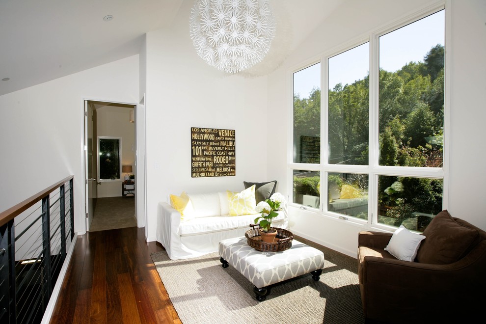 Imagen de sala de estar tipo loft contemporánea pequeña sin chimenea y televisor con paredes blancas y suelo de madera oscura