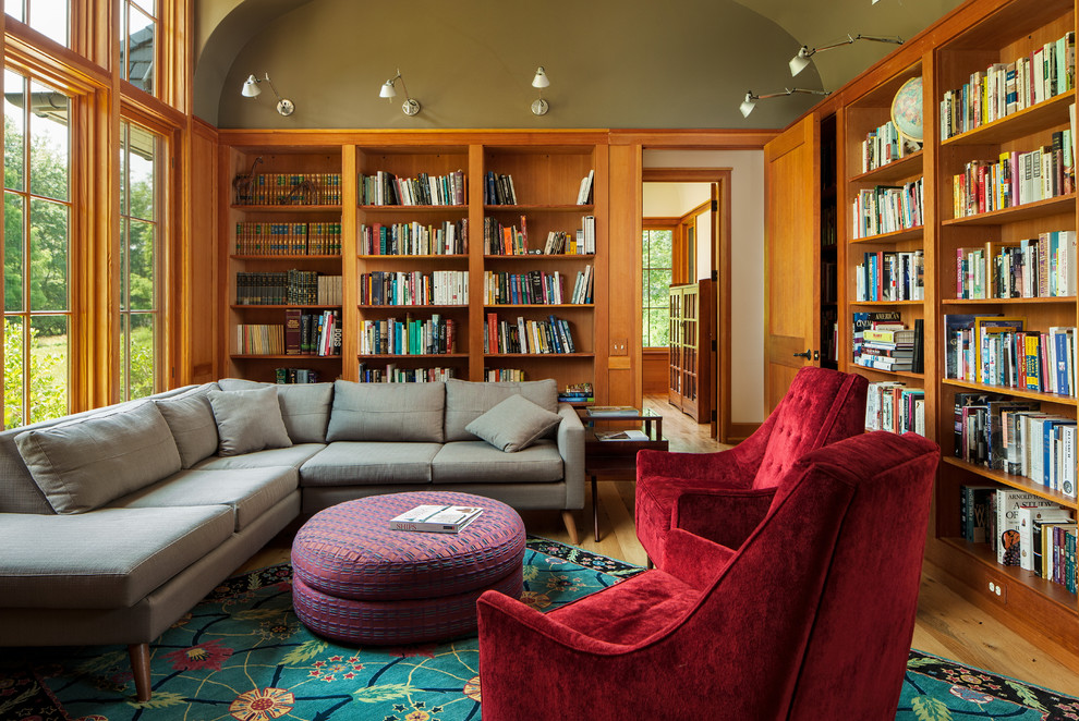 Idées déco pour une salle de séjour craftsman fermée avec une bibliothèque ou un coin lecture, parquet clair et un mur vert.