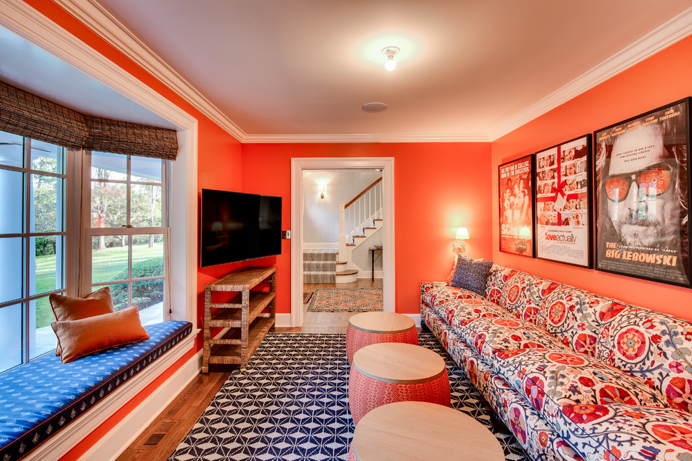 Réalisation d'une salle de séjour tradition fermée avec un mur orange, parquet foncé et un téléviseur indépendant.