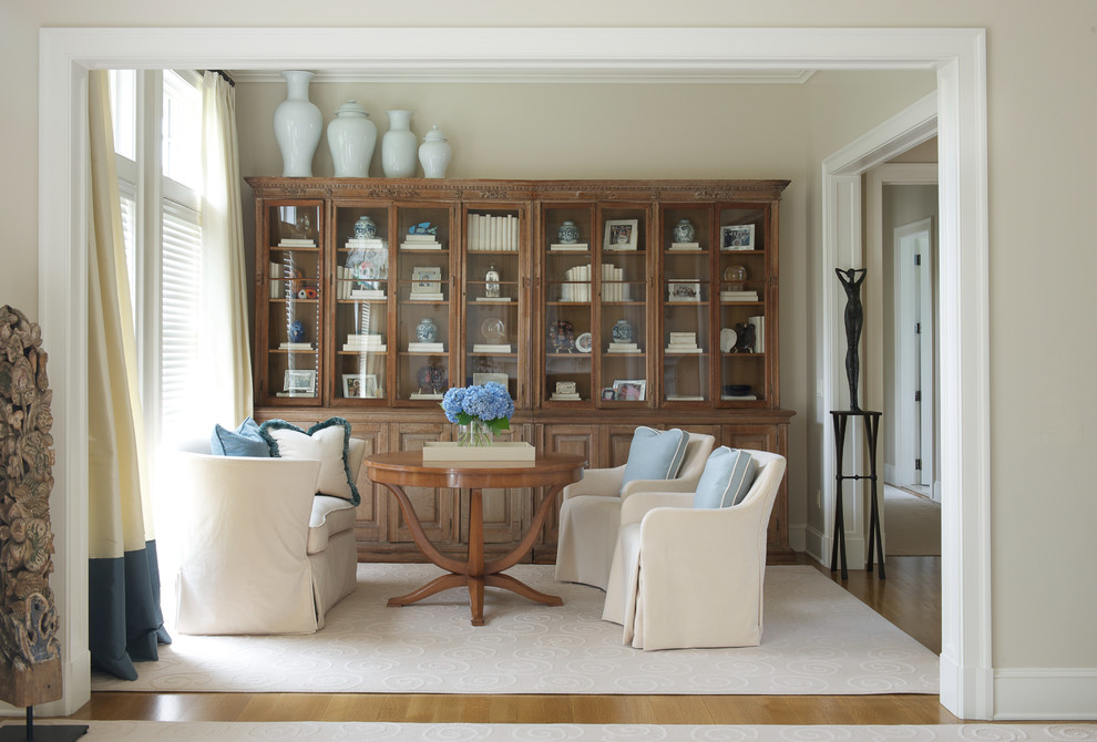 Modelo de sala de estar tradicional renovada con paredes beige y suelo de madera en tonos medios