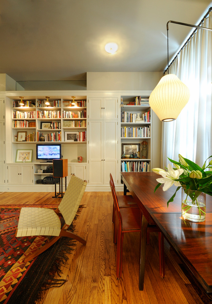 Стильный дизайн: открытая гостиная комната в стиле неоклассика (современная классика) с серыми стенами, темным паркетным полом и с книжными шкафами и полками - последний тренд