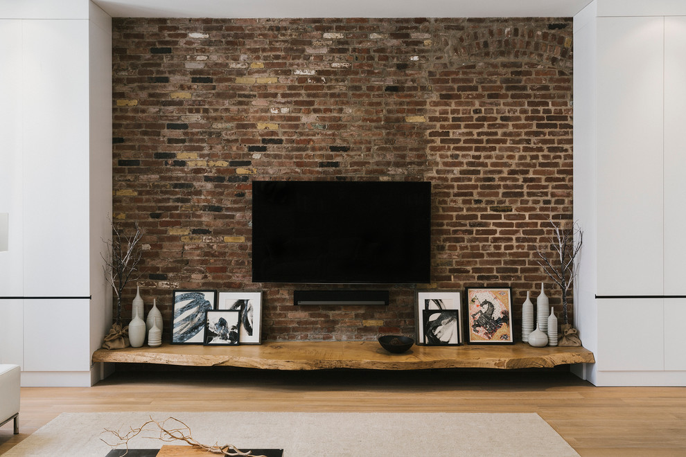 Family room - industrial open concept light wood floor family room idea in New York with white walls, a wall-mounted tv and no fireplace