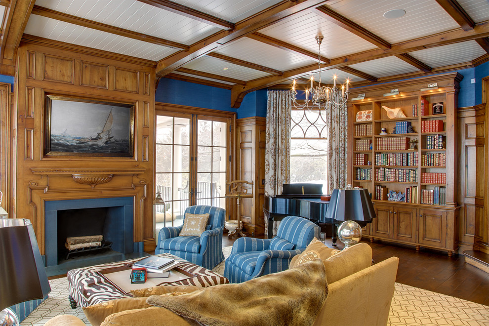 Idée de décoration pour une grande salle de séjour tradition fermée avec une bibliothèque ou un coin lecture, un mur bleu, un sol en bois brun, une cheminée standard, aucun téléviseur, un manteau de cheminée en bois et un sol marron.