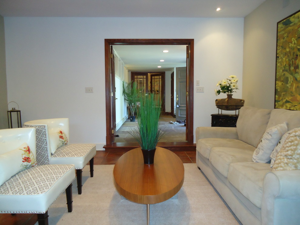 Immagine di un ampio soggiorno design aperto con pareti beige e pavimento in terracotta