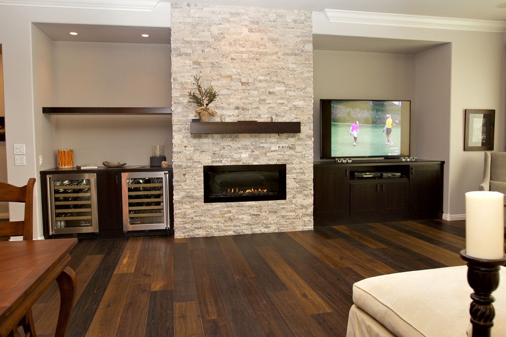 Cette image montre une salle de séjour traditionnelle de taille moyenne et ouverte avec un mur multicolore, un sol en bois brun, une cheminée standard, un manteau de cheminée en pierre et un téléviseur indépendant.