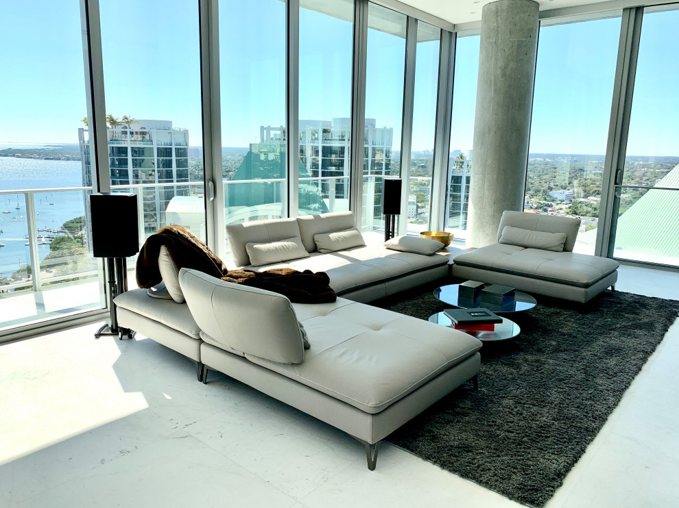 Example of a mid-sized trendy open concept marble floor and white floor family room design in Miami with white walls and a wall-mounted tv