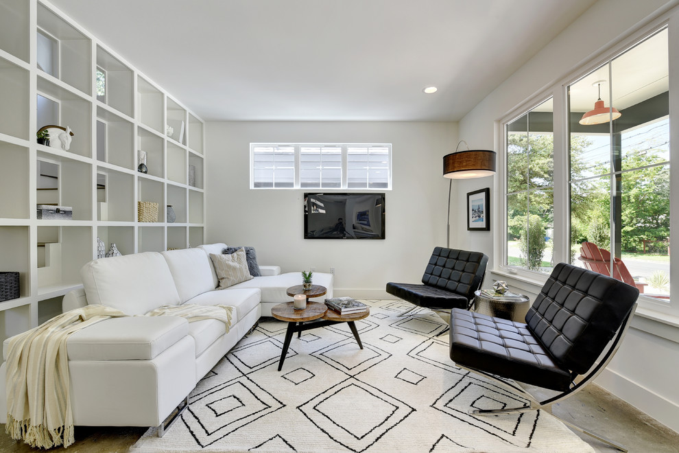 Foto de sala de estar abierta minimalista pequeña sin chimenea con paredes blancas, suelo de cemento y televisor colgado en la pared