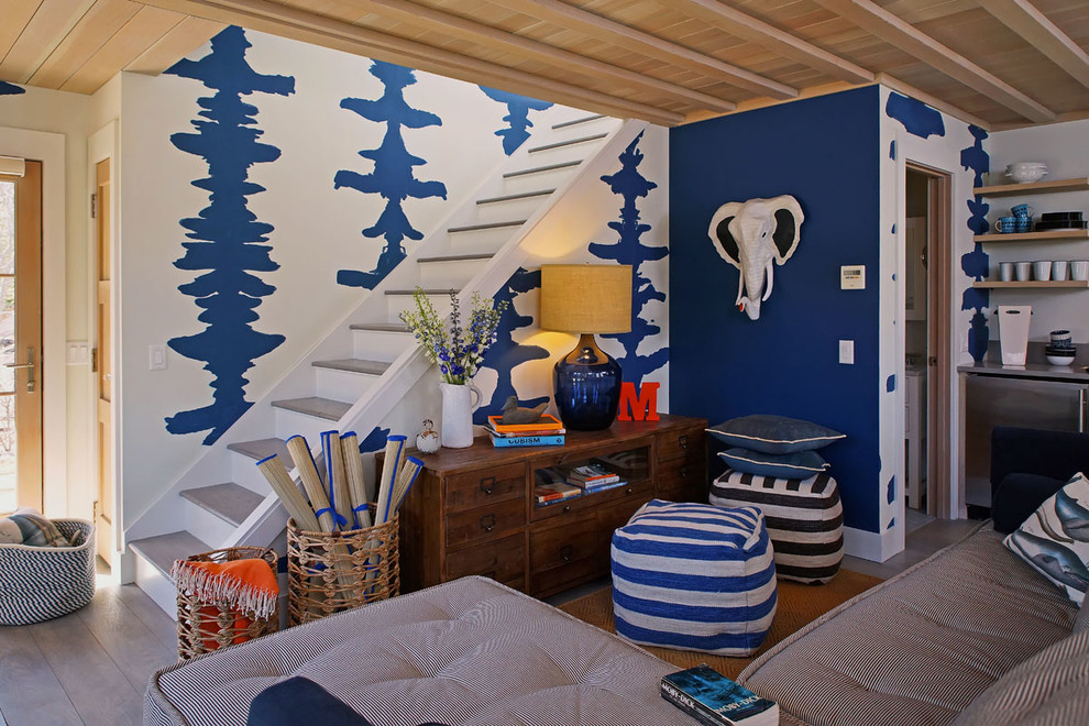 Immagine di un soggiorno minimal di medie dimensioni e chiuso con libreria, pareti blu e parquet chiaro