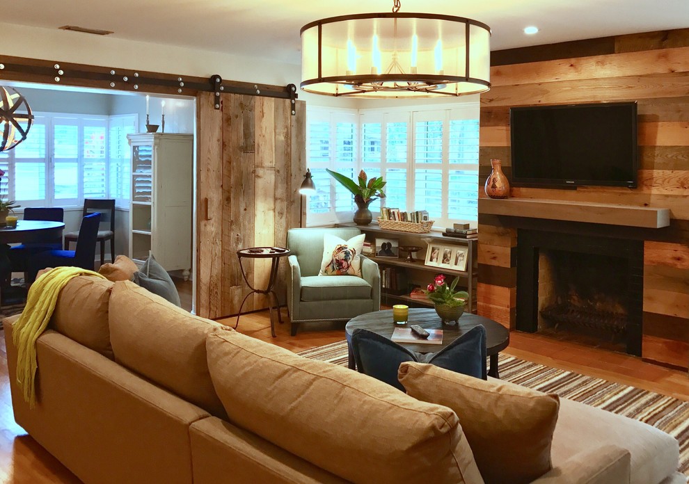 Cette photo montre une salle de séjour nature de taille moyenne et fermée avec un mur beige, un sol en bois brun, une cheminée standard, un manteau de cheminée en bois, un téléviseur fixé au mur et un sol marron.