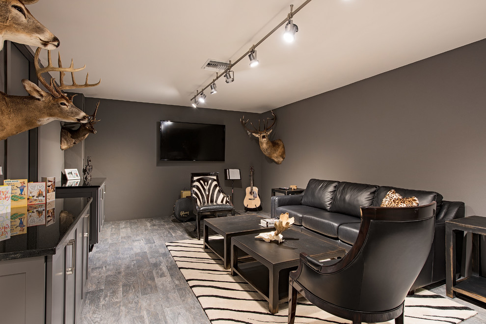 Immagine di un soggiorno classico di medie dimensioni e chiuso con angolo bar, pareti grigie, parquet chiaro e TV a parete