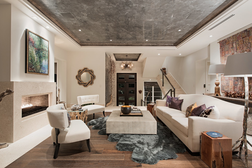 Стильный дизайн: открытая гостиная комната среднего размера в стиле неоклассика (современная классика) с фасадом камина из камня, белыми стенами, темным паркетным полом и горизонтальным камином - последний тренд