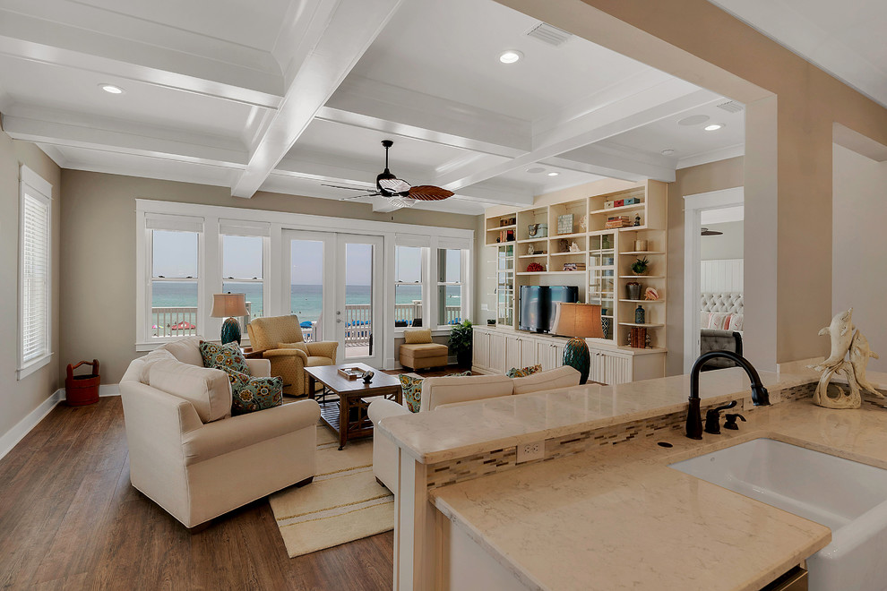 Example of a mid-sized beach style open concept medium tone wood floor and brown floor family room design in Miami with beige walls, no fireplace and a tv stand