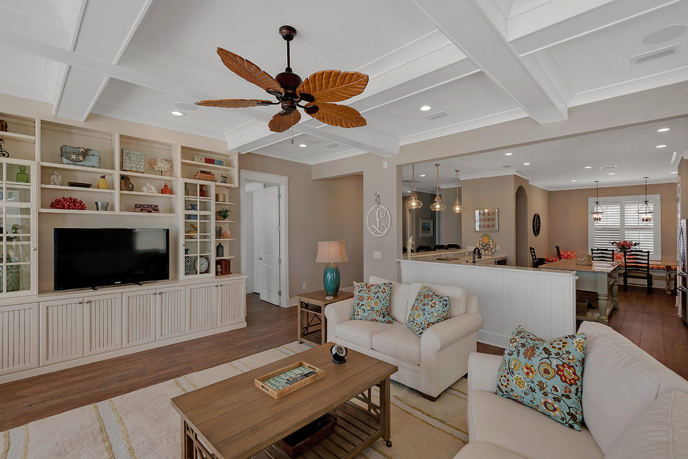 Inspiration for a mid-sized coastal open concept medium tone wood floor and brown floor family room remodel in Miami with beige walls, no fireplace and a tv stand