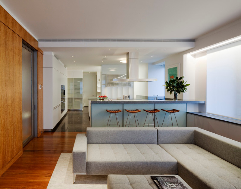 Großes, Offenes Modernes Wohnzimmer ohne Kamin mit weißer Wandfarbe, braunem Holzboden, Multimediawand und braunem Boden in New York