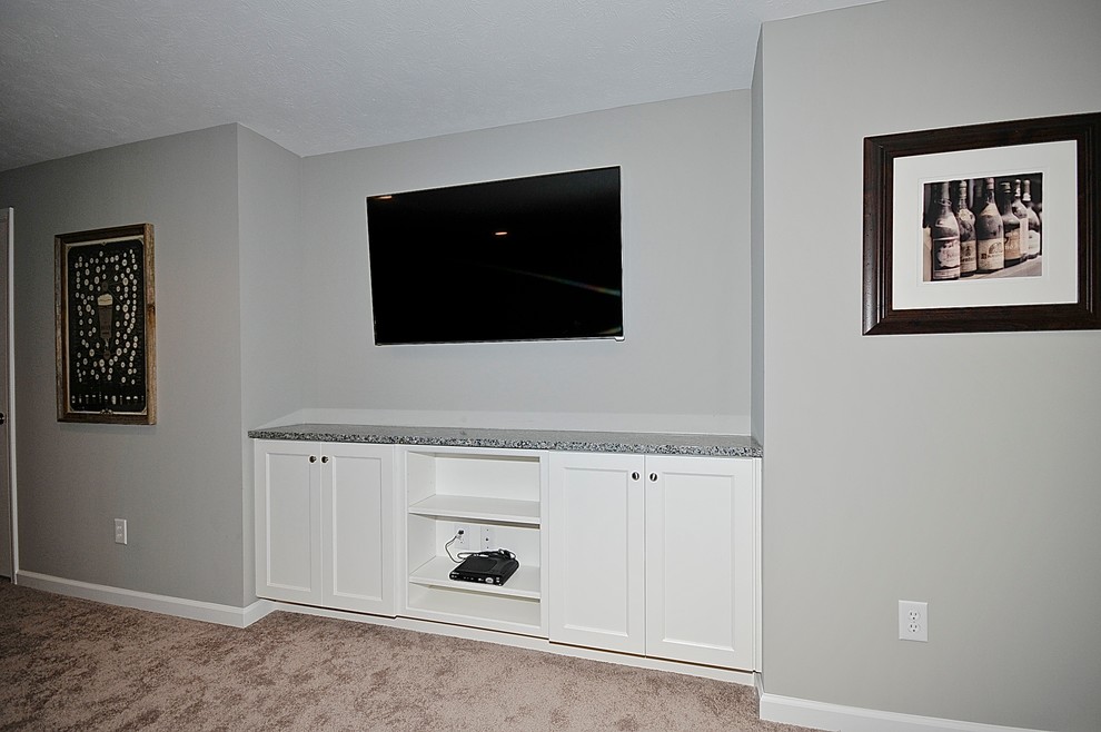 Foto di un soggiorno design aperto con angolo bar, pareti grigie, moquette e TV a parete
