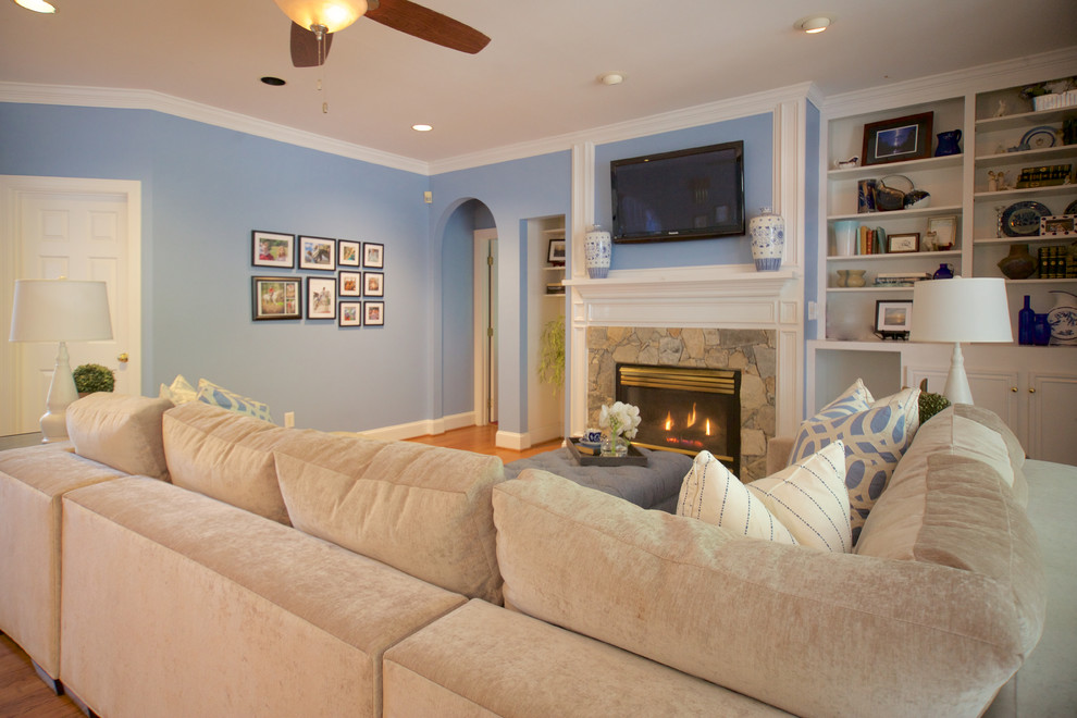 Inspiration for a medium sized nautical open plan games room in Raleigh with blue walls, light hardwood flooring, brown floors, a standard fireplace, a stone fireplace surround and a wall mounted tv.