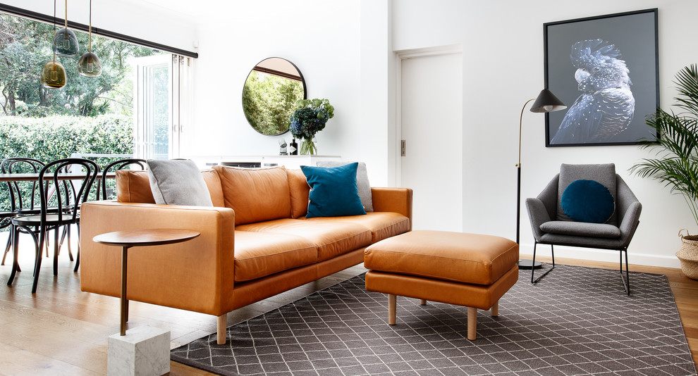 Exemple d'une grande salle de séjour scandinave ouverte avec un bar de salon, un mur blanc, un sol en bois brun, un téléviseur indépendant et un sol marron.