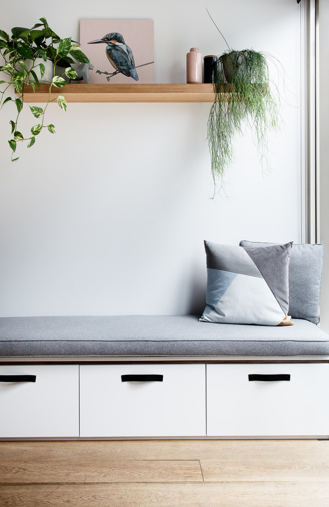 Idéer för mellanstora minimalistiska allrum med öppen planlösning, med en hemmabar, vita väggar, mellanmörkt trägolv, en fristående TV och brunt golv