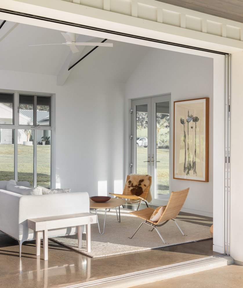 Diseño de sala de estar abierta campestre pequeña con paredes blancas y suelo de cemento